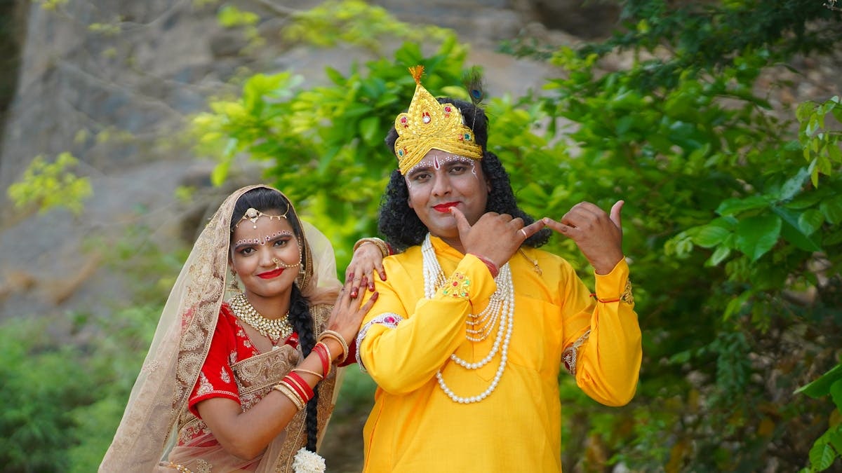 A couple in vibrant traditional Indian clothing posing outdoors, embodying cultural elegance.